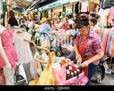 Une femme a tendance à avoir des produits sur son marché dans la rue très fréquentée de Bangkok. Banque D'Images