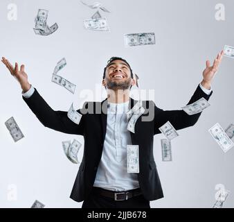 Ce n'est pas lui qui a beaucoup est riche. Studio photo d'un homme bien habillé qui jette de l'argent dans les airs autour de lui. Banque D'Images