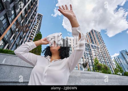 Femme multiraciale en plein air portant des lunettes de réalité virtuelle Banque D'Images