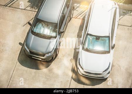 Surface réfléchissante de protection sous le pare-brise des voitures de tourisme blanches et argentées garées par temps chaud, chauffées par les rayons du soleil à l'intérieur de la voiture Banque D'Images