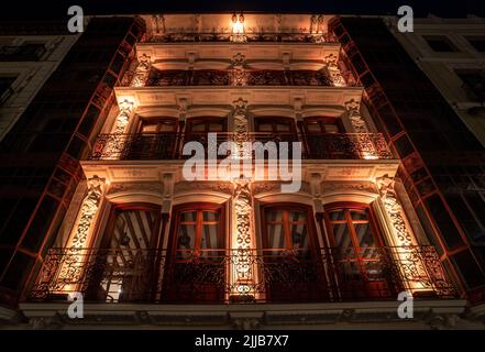 Bâtiment de luxe et décoré avec des moulures ornementales magnifiquement éclairé la nuit. Banque D'Images