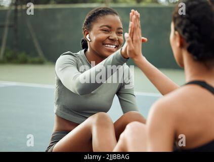 Ils font des entraînements écrasants. Deux jeunes athlètes féminines attirantes se mettent en train de jouer sur un terrain de sport. Banque D'Images