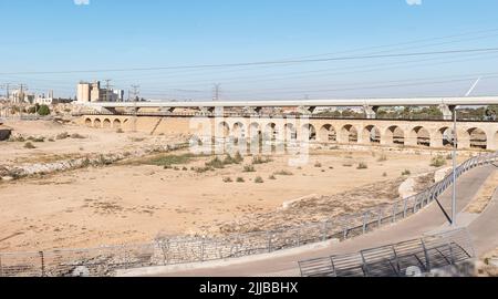 Un pont ferroviaire moderne traverse la rivière Beer Sheva en face de l'ancien pont ferroviaire de l'époque ottomane avec une piste cyclable moderne au premier plan Banque D'Images