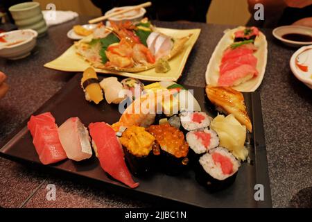 Gros plan assortiment de petits pains à sushi et de sashimi : saumon, thon, crevettes, anguille, Uni, Hamachi, œuf et poulpe Banque D'Images