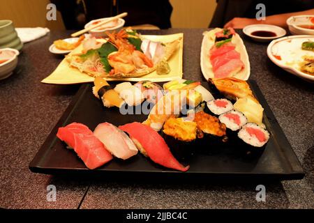 Gros plan assortiment de petits pains à sushi et de sashimi : saumon, thon, crevettes, anguille, Uni, Hamachi, œuf et poulpe Banque D'Images