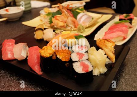 Gros plan assortiment de petits pains à sushi et de sashimi : saumon, thon, crevettes, anguille, Uni, Hamachi, œuf et poulpe Banque D'Images