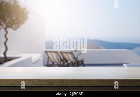 Table en bois vide sur fond flou de patio ensoleillé en bord de mer. Banque D'Images