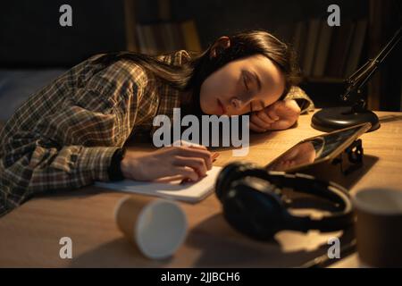 Femme étudiante asiatique fatiguée dormant à table à la maison de nuit. Travailler de la surcharge de la maison la nuit, les heures supplémentaires, l'éducation et la fatigue Banque D'Images