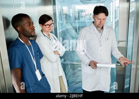 Divers groupes de médecins en ascenseur dans un bâtiment hospitalier moderne Banque D'Images