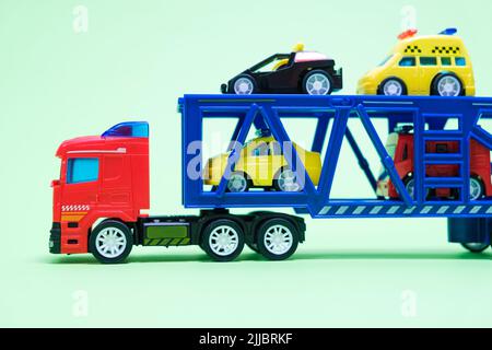 Véhicule de transport en plastique jouet rouge avec équipement spécial à l'intérieur sur fond vert, jouets pour garçons Banque D'Images