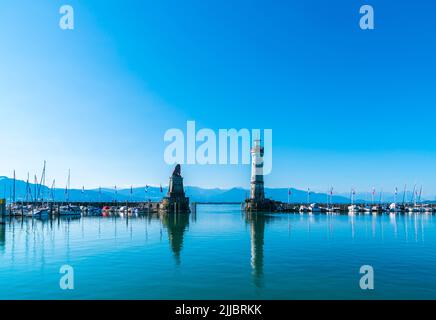 Allemagne, phare du port de l'île de Lindau et belle vue panoramique sur l'autriche et la ville de bregenz tôt le matin avec ciel bleu et soleil Banque D'Images