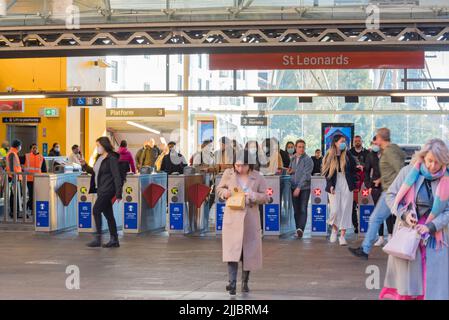 Certains portent des masques à l'aide de leur carte opale pour passer par les portes d'entrée à la gare St Leonards, un matin d'hiver à Sydney, en Australie Banque D'Images