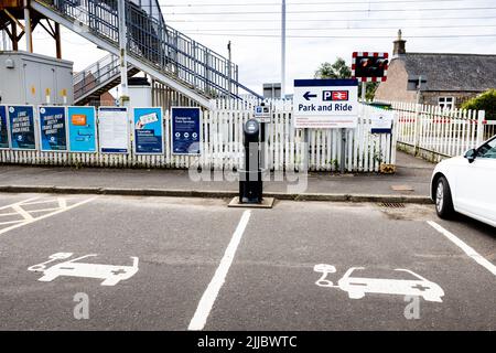 Vide, peint en blanc et marqué, les aires de stationnement et le point de charge des véhicules électriques désignés pour deux véhicules avec des panneaux à une gare du Royaume-Uni Banque D'Images