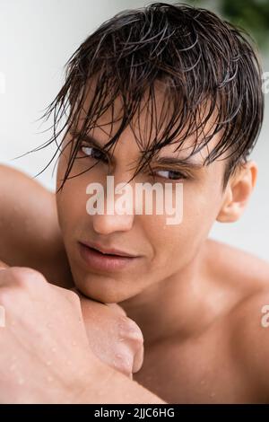 portrait d'un homme aux cheveux mouillés et au visage parfait sur fond blanc Banque D'Images