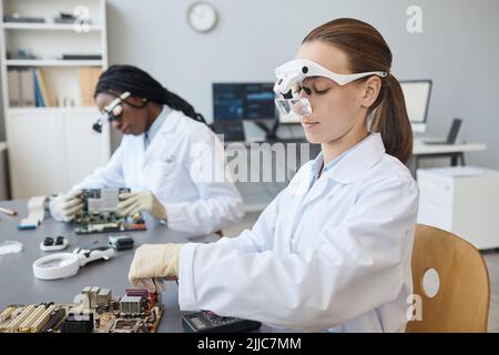 Portrait de deux jeunes femmes ingénieurs travaillant avec des pièces électroniques en laboratoire, espace de copie Banque D'Images