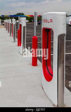 Elkhart, Indiana - postes de charge pour les véhicules électriques Tesla à côté d'une station-service Sunoco sur la route à péage de l'Indiana. Banque D'Images