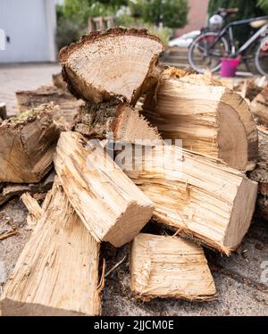 25 juillet 2022, Hessen, Francfort-sur-le-main : le bois de chauffage fraîchement livré se trouve devant un garage appartenant à une maison de rangée. Photo: Frank Rumpenhorst/dpa Banque D'Images