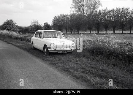 1970s, historique, un gentleman assis dans le siège passager d'une voiture de l'époque de Triumph Dolomite, garée sur une verge herbeuse à côté d'une route rurale, Angleterre, Royaume-Uni. Petite berline, la Dolomite Triumph a été fabriquée par la compagnie de moteurs de Tiumph qui faisait partie de la société hugh British Leyland Corporation (BL. La voiture a été produite à Canley, Coventry, entre 1972 et 1980. Banque D'Images