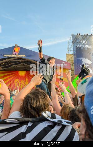 Bruce Springsteen se produit avec un microphone étendu à la main au sein de la foule au festival de jazz et de patrimoine de la Nouvelle-Orléans sur 29 avril 2012 Banque D'Images