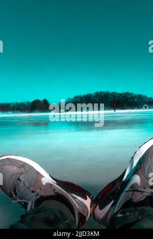 Un cliché vertical des chaussures d'une personne assise sur un lac gelé pendant l'hiver Banque D'Images