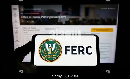 Personne tenant un smartphone avec le logo de la Federal Energy Regulatory Commission (FERC) des États-Unis à l'écran devant le site Web. Mise au point sur l'affichage du téléphone. Banque D'Images