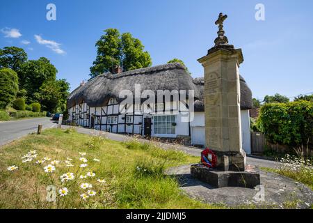 Chalets de chaume et le mémorial de guerre dans la place du village, Wherwell, Test Valley, Hampshire, Angleterre, Royaume-Uni, Europe Banque D'Images