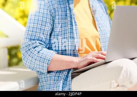 Femme âgée méconnue utilisant un ordinateur portable pour l'apprentissage à distance à l'extérieur Banque D'Images