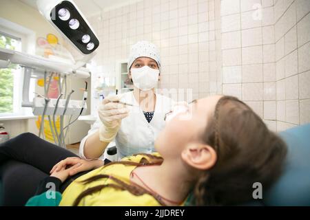 Le médecin traite les dents de l'enfant du patient.enfant dans le cabinet du dentiste Banque D'Images