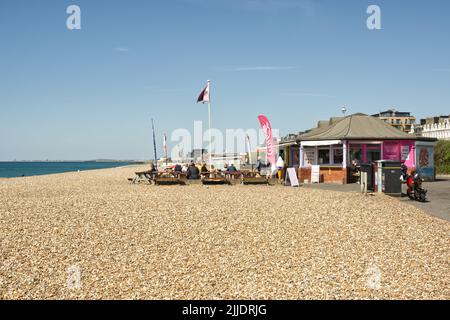 Café en plein air sur la plage de galets à Hove, Brighton, East Sussex, Angleterre. Avec des gens assis à des tables manger et boire. Banque D'Images