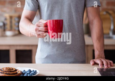 thé du matin café mauvaise habitude petit déjeuner homme tasse rouge Banque D'Images