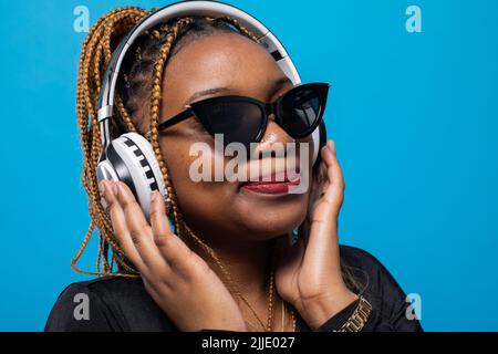 Un gros plan d'une jeune femme à la peau sombre qui écoute de la musique. Banque D'Images