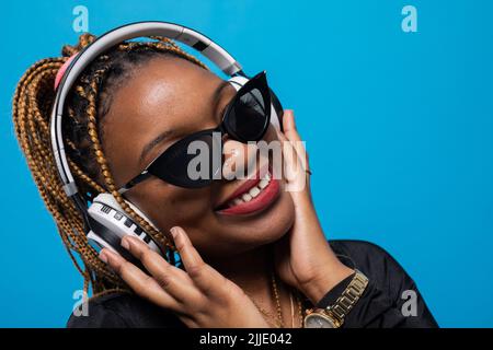 Un gros plan d'une jeune femme à la peau sombre qui écoute de la musique. Banque D'Images