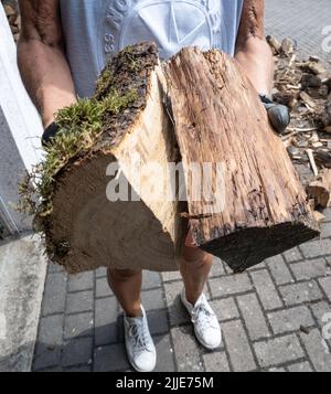 25 juillet 2022, Hessen, Francfort-sur-le-main : un résident transporte du bois de chauffage fraîchement livré dans un garage. Photo: Frank Rumpenhorst/dpa Banque D'Images