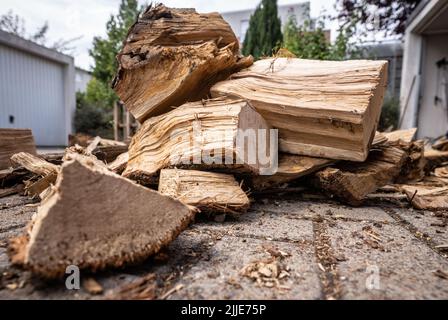 25 juillet 2022, Hessen, Francfort-sur-le-main : le bois de chauffage fraîchement livré se trouve devant un garage appartenant à une maison de rangée. Photo: Frank Rumpenhorst/dpa Banque D'Images