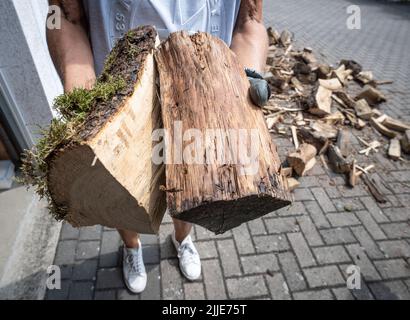 25 juillet 2022, Hessen, Francfort-sur-le-main : un résident transporte du bois de chauffage fraîchement livré dans un garage. Photo: Frank Rumpenhorst/dpa Banque D'Images