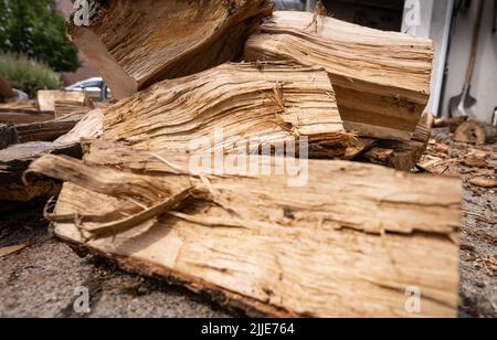 25 juillet 2022, Hessen, Francfort-sur-le-main : le bois de chauffage fraîchement livré se trouve devant un garage appartenant à une maison de rangée. Photo: Frank Rumpenhorst/dpa Banque D'Images