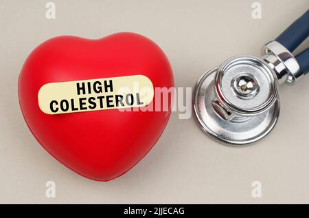 Concept de médecine. Près du stéthoscope se trouve un coeur sur lequel un autocollant est collé avec l'inscription - High Colesterol Banque D'Images