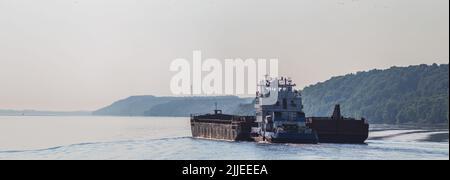 Une grande barge transporte du fret par rivière vers le port principal pour le chargement sur de grands navires destinés à l'exportation. Transport de la cargaison par l'eau Banque D'Images