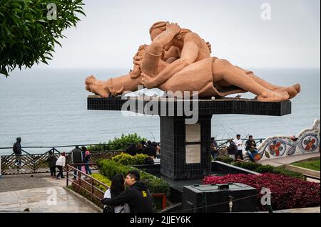 Un jeune couple embrasse devant une sculpture d'art publique intitulée 'El Beso' (le baiser) au Miraflores malecon un dimanche après-midi. Banque D'Images