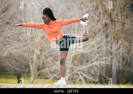 Trouver mon solde. Prise de vue en longueur d'une jeune femme attrayante debout et s'étirant avant de faire de l'exercice à l'extérieur. Banque D'Images