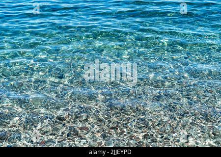 Gros plan photo de l'eau cristalline de la plage d'Olympos avec des galets au fond d'Antalya comme un été, détente, arrière-plan tranquille. Banque D'Images