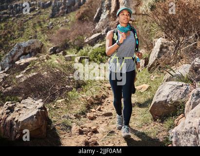 Je me montrerai que je peux le faire. Une jeune femme qui court le long d'un sentier sur la montagne. Banque D'Images