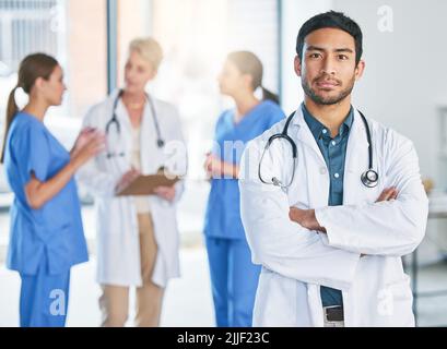 Le succès signifie faire de notre mieux. Un jeune homme médecin debout à l'hôpital. Banque D'Images