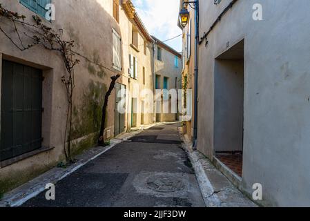 Vieille rue du village de Gruissan, dans le sud de la France, avec des murs de couleur beige et rose, prise sur un hiver ensoleillé en fin d'après-midi sans personne Banque D'Images