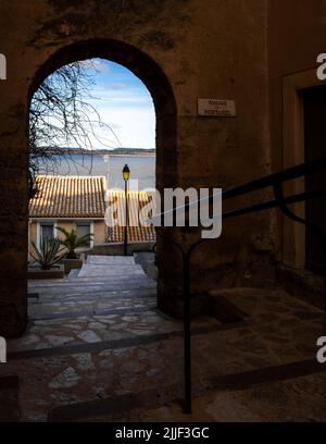 Vieille rue du village de Gruissan, dans le sud de la France, avec une porte ouvrant sur un lac, prise en hiver ensoleillé en fin d'après-midi sans personne Banque D'Images