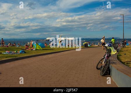 Izola, Slovénie - 9th juillet 2022. Les habitants de la région et les touristes apprécient le soleil du week-end d'été dans le parc de la Plaza Izola plage de la ville sur la côte Adriatique Banque D'Images