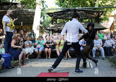 Le public regarde comme acteurs de théâtre exécuter "Odessa, je vous aime" sur le marché du livre à Odessa. La performance "Odessa, je t'aime" raconte des histoires de la vie des habitants d'Odessa avec sa couleur caractéristique et son humour. La représentation a été mise en scène par les acteurs du Théâtre n° 7 et jouée à l'extérieur sur le marché du livre. Le but de cette performance est de recueillir des dons pour les besoins de défense aérienne. Banque D'Images