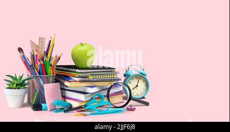 Composition des fournitures scolaires isolée sur fond rose Banque D'Images