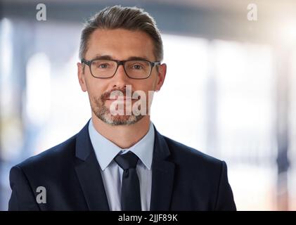 Mettez votre être dans votre agitation. Portrait d'un homme d'affaires mature debout dans un bureau moderne au travail. Banque D'Images