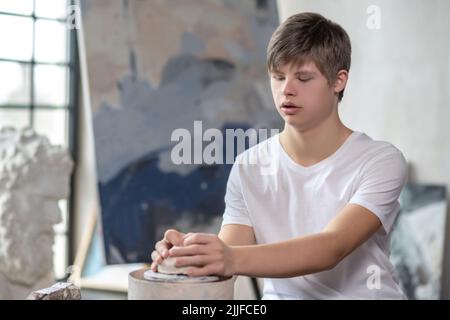 Un garçon faisant un pot dans un studio d'art Banque D'Images